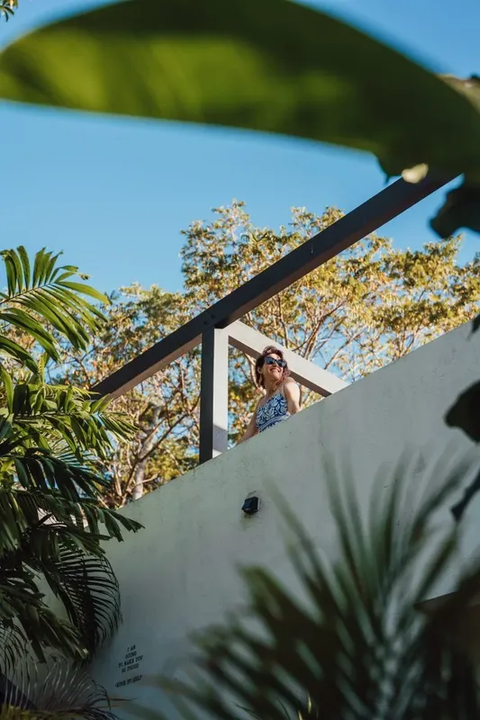 Femme souriante avec des lunettes de soleil sur une terrasse ensoleillée