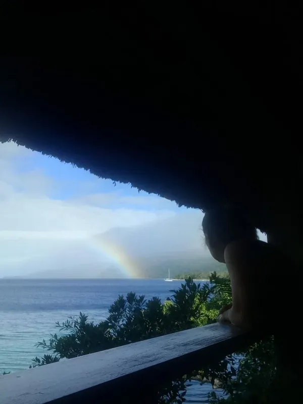 Vue sur la mer avec arc-en-ciel et personne regardant le paysage