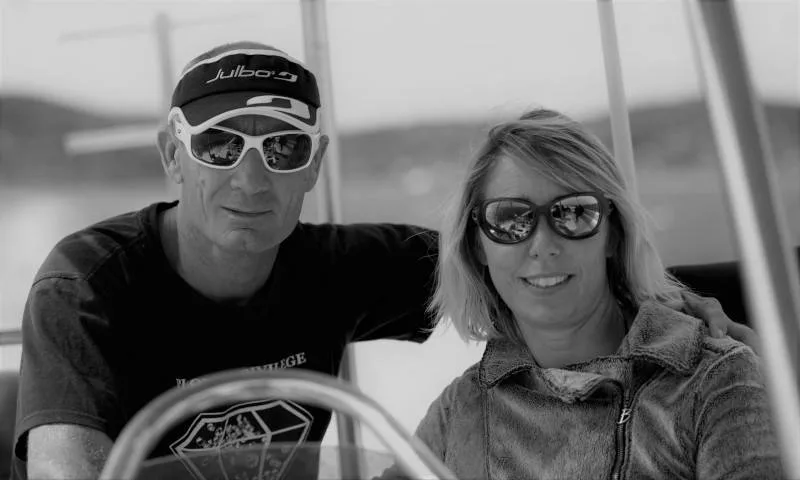 Deux personnes souriantes avec des lunettes de soleil sur un bateau