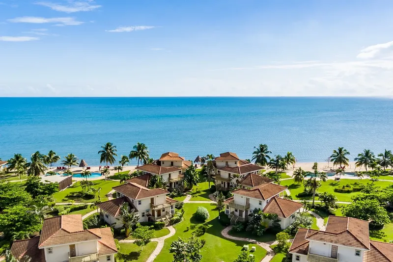 Vue aérienne d'un complexe hôtelier tropical avec mer turquoise et palmiers