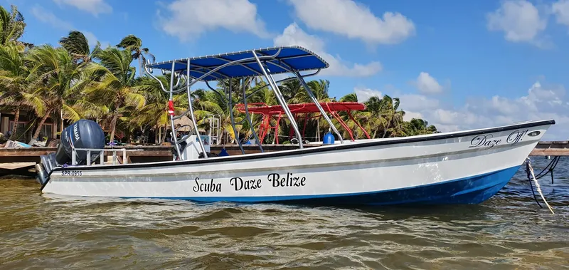 Bateau de plongée amarré à quai avec le texte Scuba Daze Belize