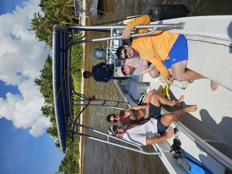 Quatre personnes sourient et se détendent sur un bateau de plongée