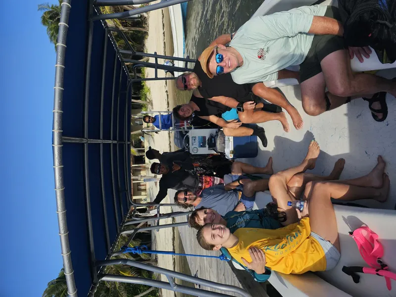 Groupe de plongeurs souriants sur un bateau en mer ensoleillée