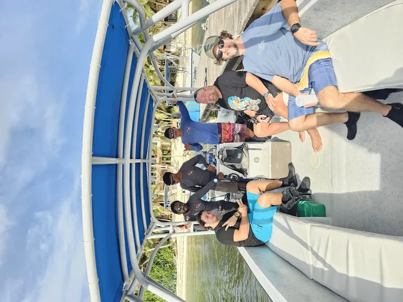 Groupe de personnes assises sur un bateau de plongée ensoleillé