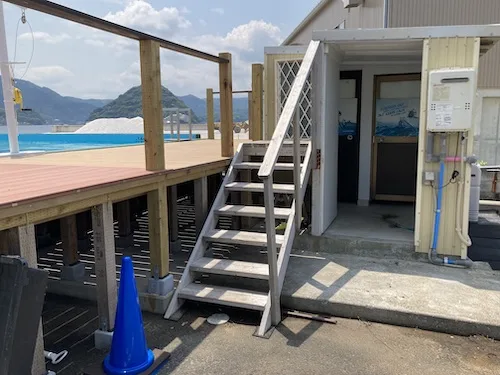 Escalier menant à une plateforme en bois près d'un bâtiment