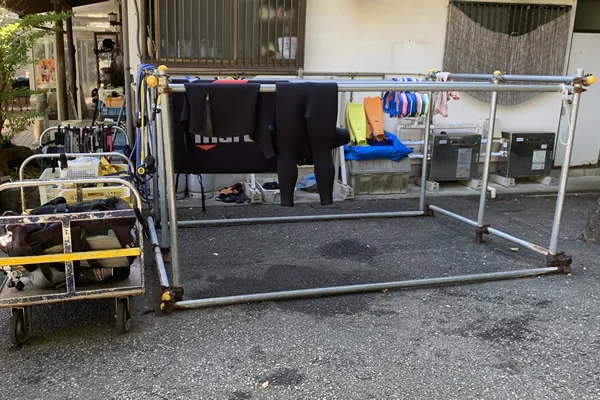 Équipement de plongée séchant sur un étendoir devant un bâtiment