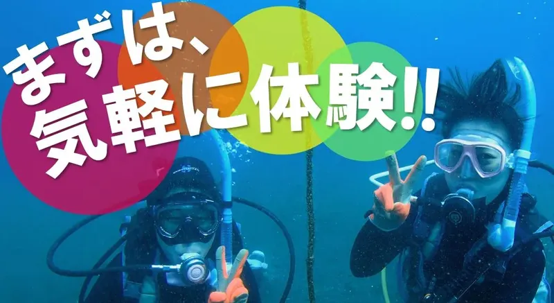 Deux plongeuses souriantes font un signe de la main sous l'eau