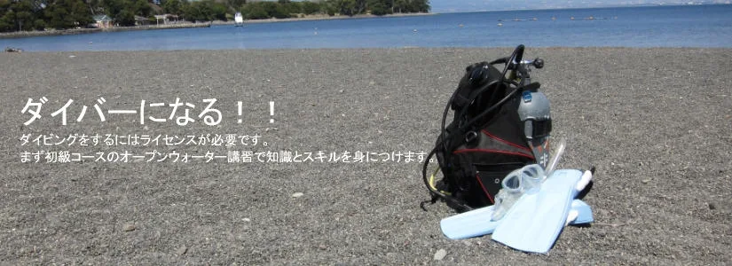 Equipement de plongée sur une plage de sable gris avec texte en japonais