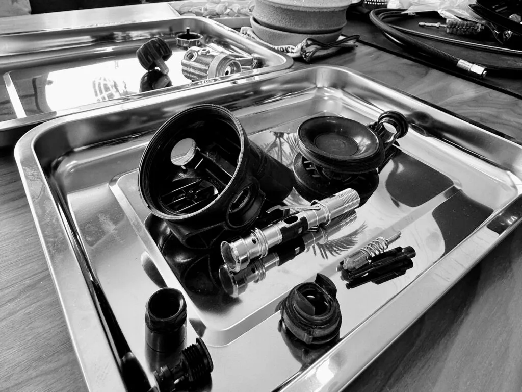 Pieces detachees d'un detendeur de plongée dans un bac metallique