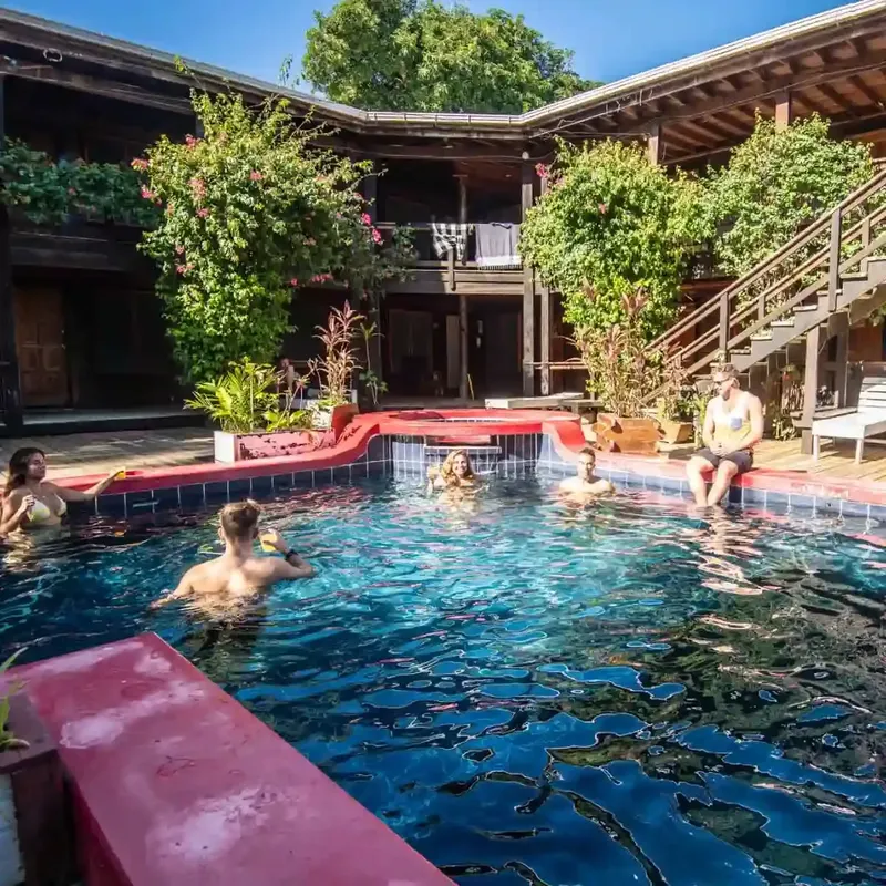 Personnes se relaxent et discutent autour d'une piscine ensoleillée