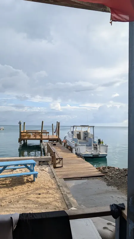 Vue sur un ponton avec un bateau de plongée et des personnes
