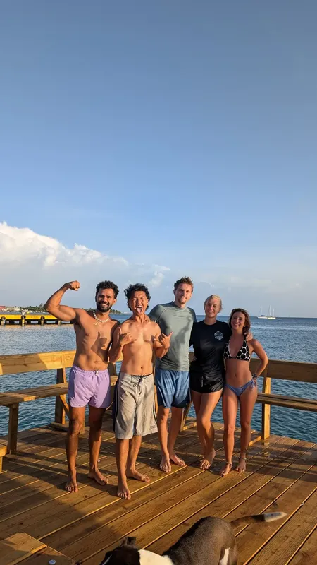 Groupe de personnes souriantes sur un ponton en bois ensoleillé