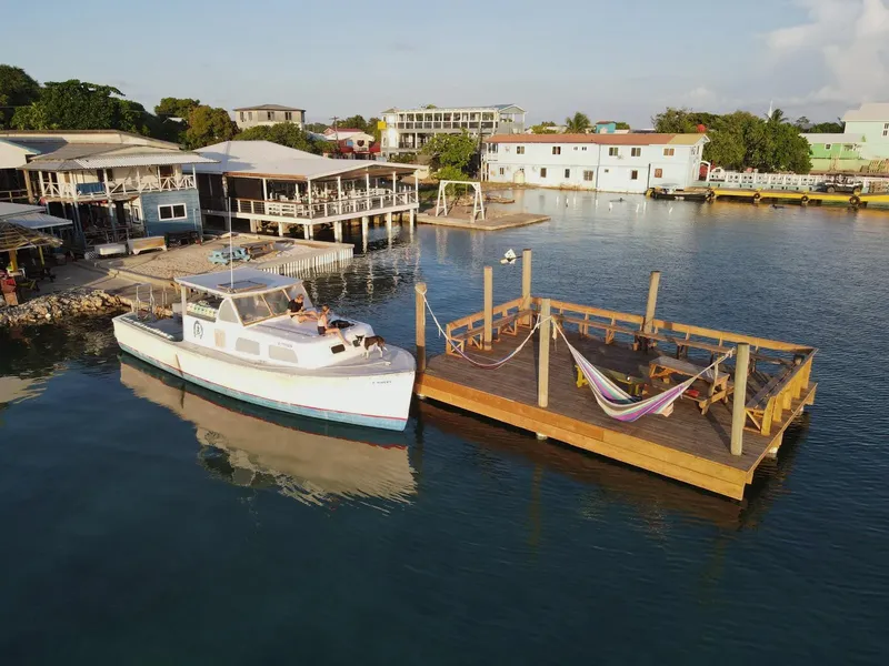 Bateau de plongée amarré à un ponton avec des hamacs et bâtiments