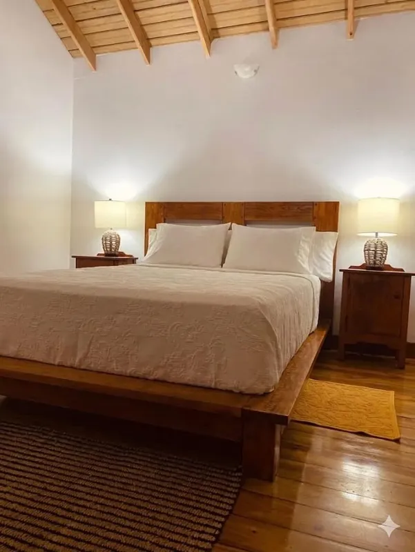 Chambre avec un grand lit en bois et deux lampes de chevet