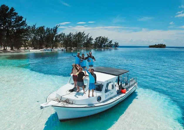 Groupe de personnes souriantes sur un bateau en mer turquoise