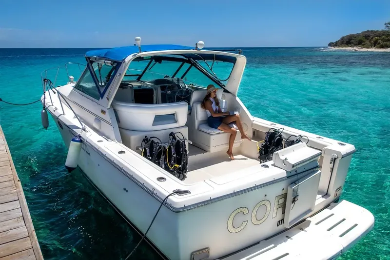 Bateau de plongée amarré à quai avec une personne et du matériel