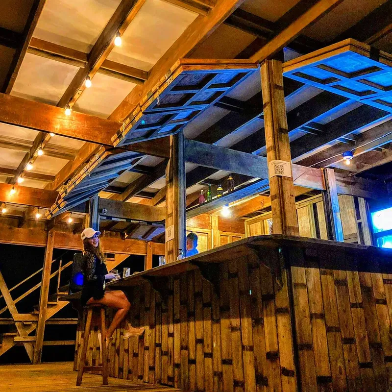 Bar en bois avec une personne assise sur un tabouret