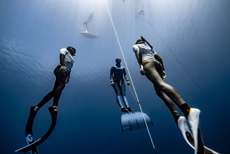 Apnée : trois plongeurs descendent le long d'un câble vertical