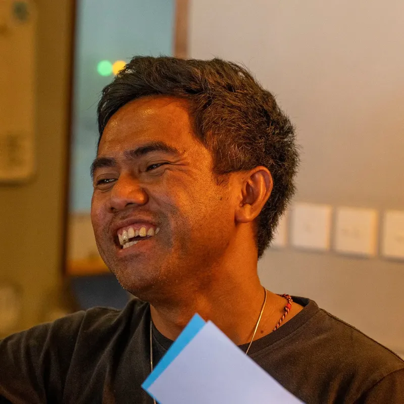Portrait d'un homme souriant, regardant vers le haut, intérieur clair
