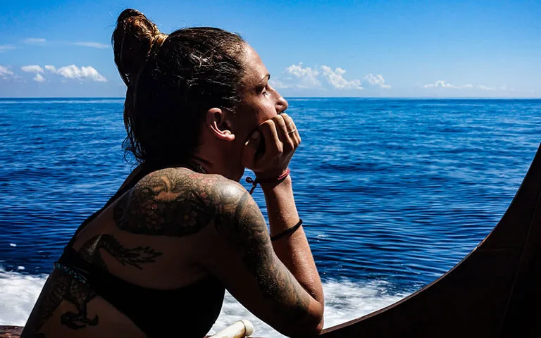 Femme regardant l'horizon depuis un bateau en pleine mer