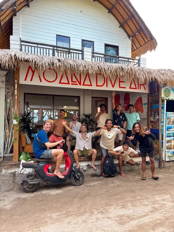 Groupe de personnes souriantes devant la façade d'un centre de plongée