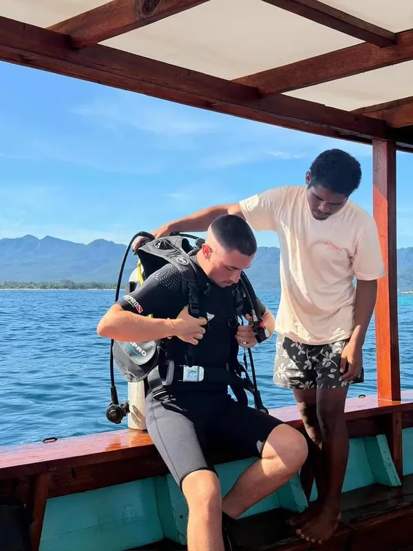 Plongeur s'équipant sur un bateau avec l'aide d'un moniteur