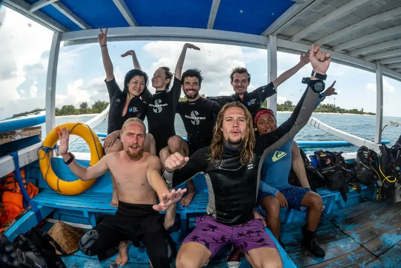 Groupe de plongeurs joyeux à bord d'un bateau bleu et blanc