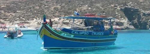 Bateau de croisière bleu et jaune amarré dans une crique turquoise