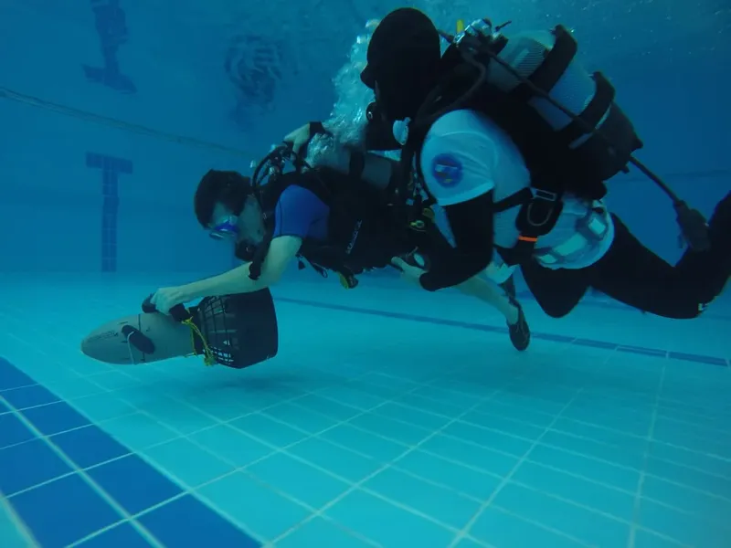 Deux plongeurs en formation dans une piscine, équipement complet visible