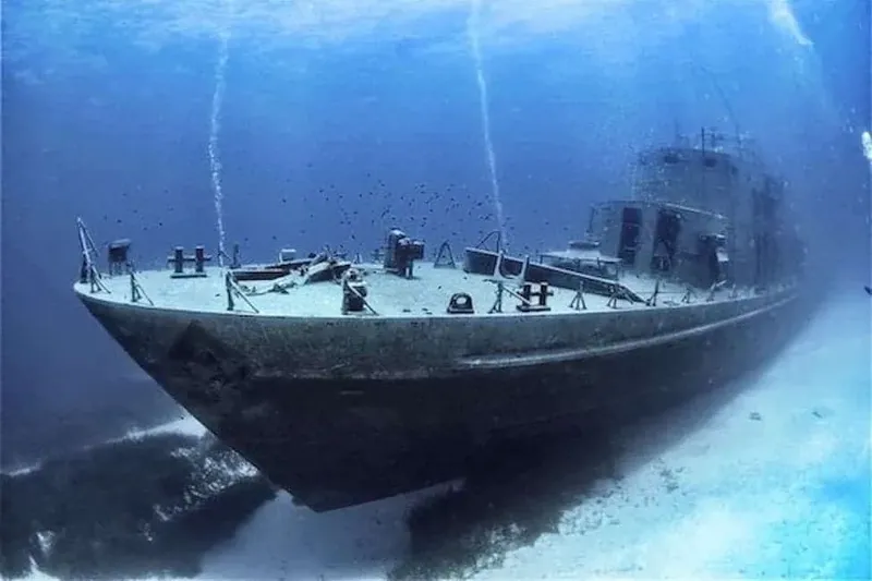 Épave de bateau coulé, vue sous-marine, lumière bleutée, sable