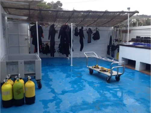 Bouteilles de plongée, combinaisons et matériel d'équipement sur une terrasse bleue