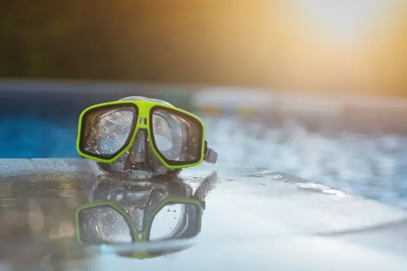 Masque de plongée vert et noir sur une surface réfléchissante
