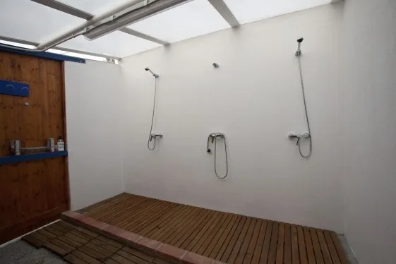 Douches intérieures avec sol en bois et équipement simple