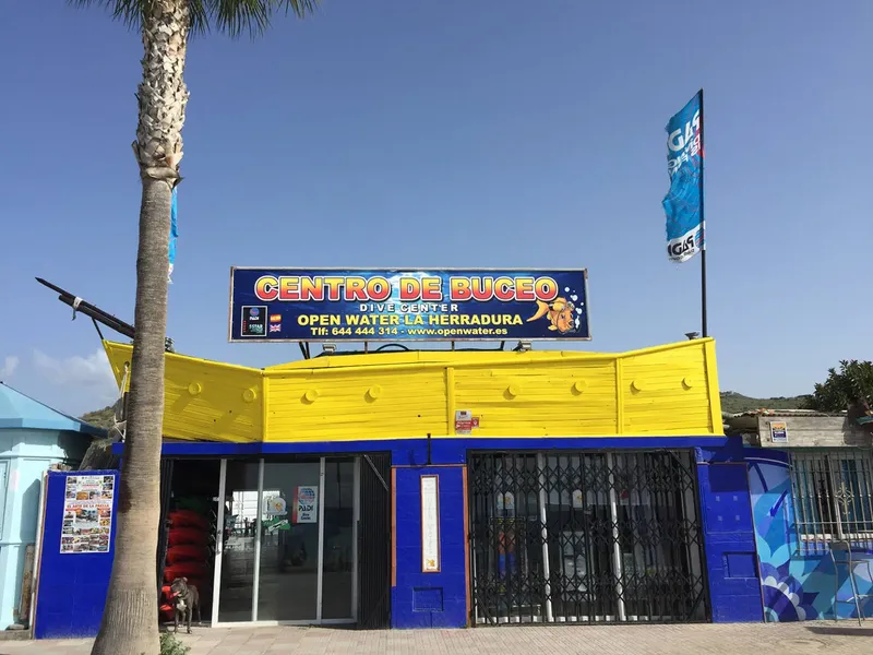 Façade jaune d'un centre de plongée avec enseigne et palmes