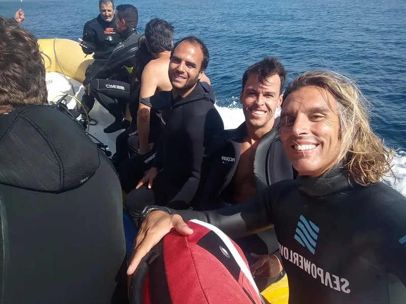 Plongeurs souriants à bord d'un bateau pneumatique en mer