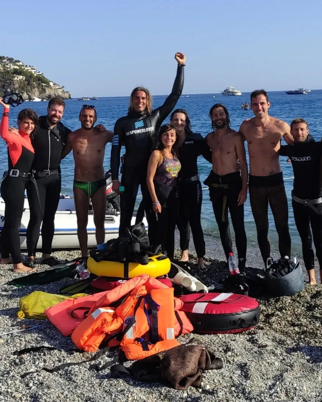 Groupe de personnes en combinaison de plongée sur une plage rocheuse