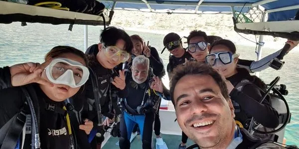 Groupe de plongeurs souriants sur un bateau en mer