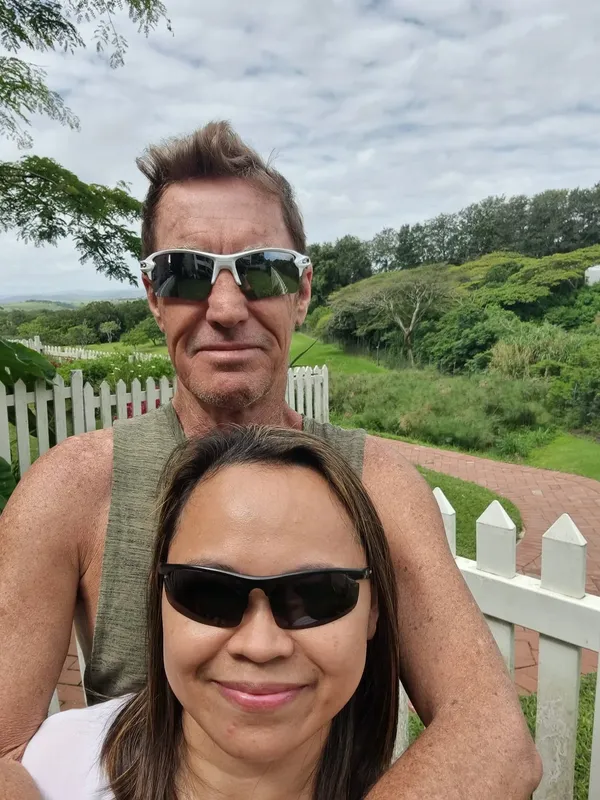 Deux personnes souriantes portant des lunettes de soleil en extérieur