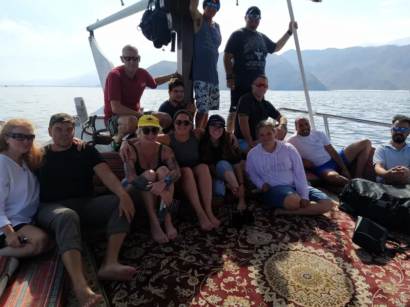 Groupe de personnes souriantes sur le pont d'un bateau en mer