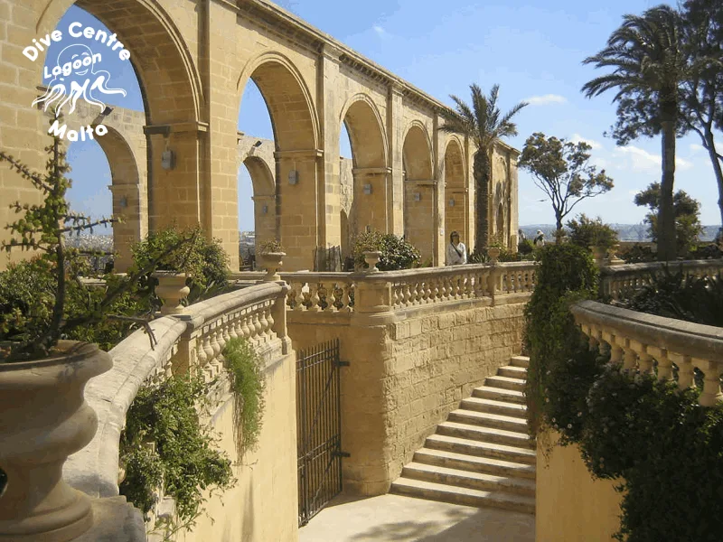 Architecture en pierre avec arcades, escalier et personnes au loin