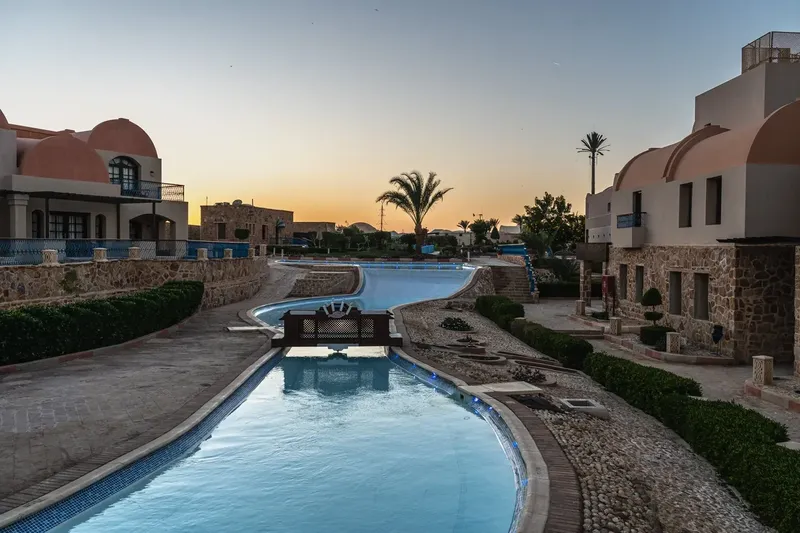 Vue d'un complexe hôtelier avec piscine et bâtiments blancs et ocres