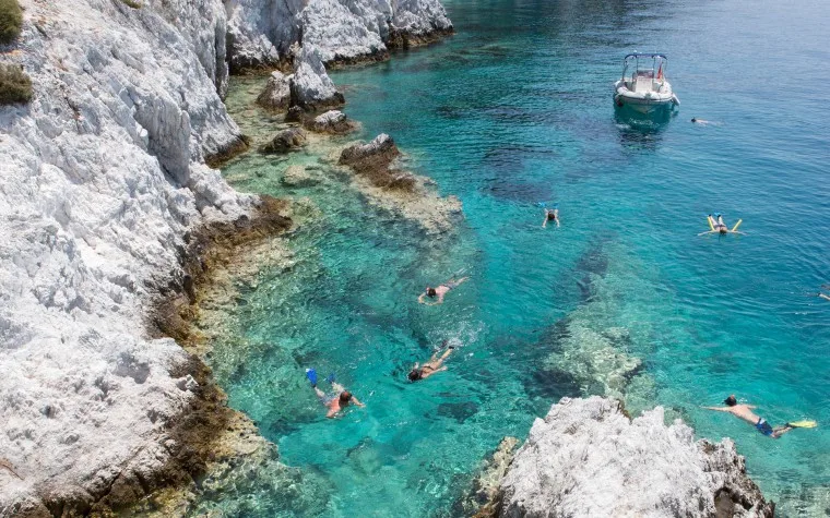 Plongée en apnée dans une eau turquoise avec des falaises rocheuses