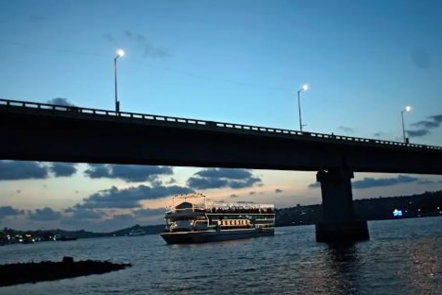 Bateau de croisière naviguant sur une rivière sous un pont éclairé