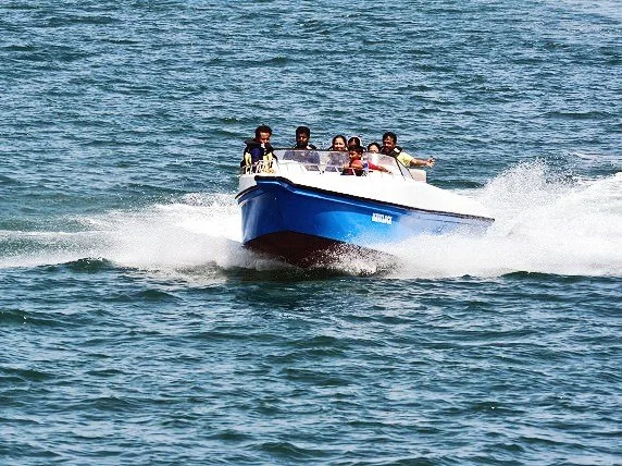 Bateau pneumatique bleu avec passagers naviguant sur une mer agitée