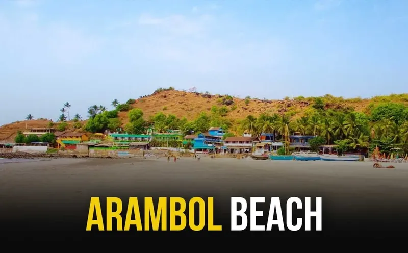 Plage d'Arambol avec des bâtiments colorés et des personnes au loin