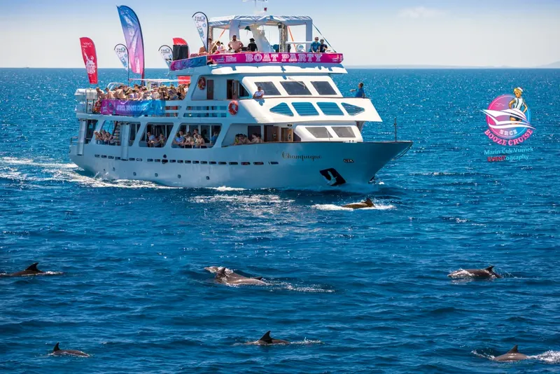 Bateau de plaisance avec des passagers et des dauphins dans l'océan