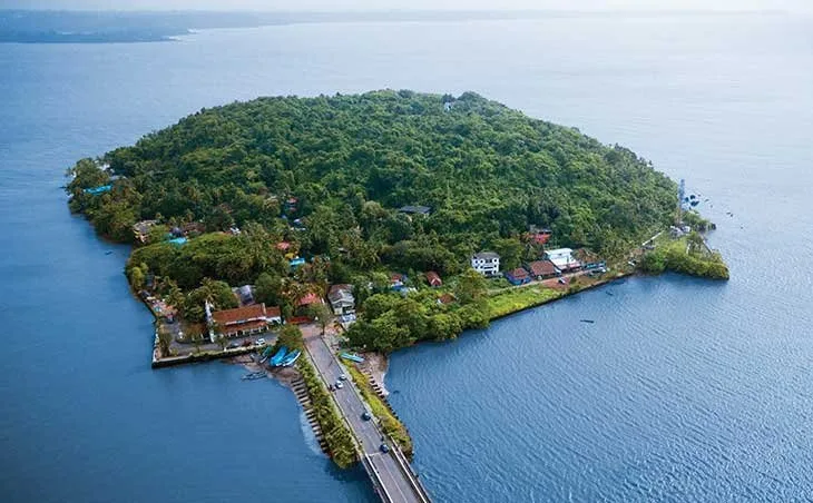 Vue aérienne d'une île tropicale avec bâtiments, route et embarcations