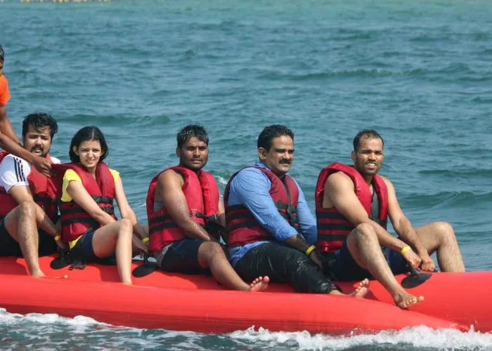Groupe de personnes souriantes en gilets de sauvetage sur un bateau rouge