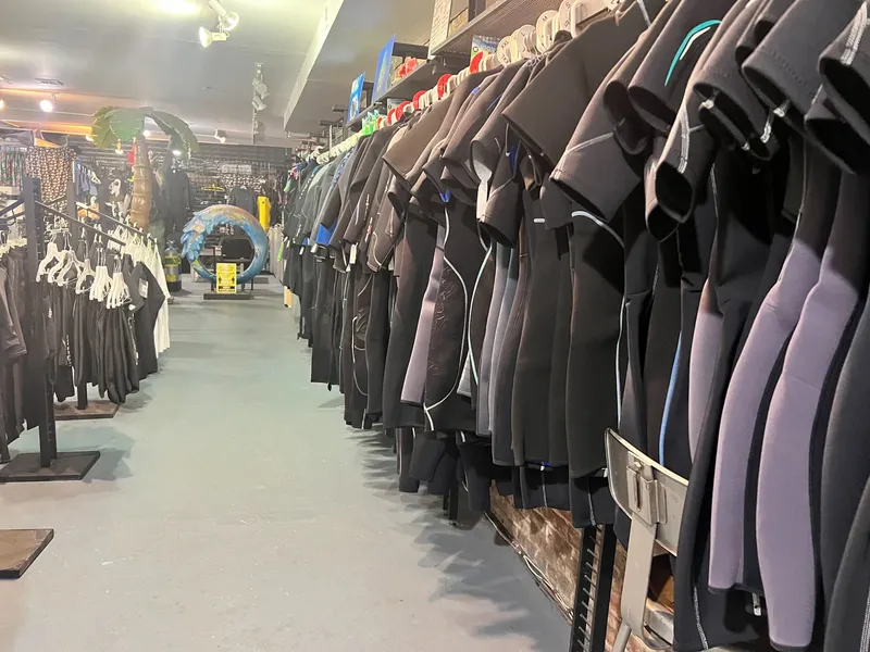 Rangées de combinaisons de plongée noires et bleues dans un magasin