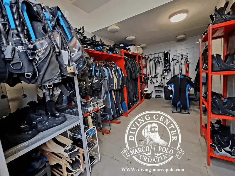 Rangées de combinaisons de plongée et équipements dans un local intérieur